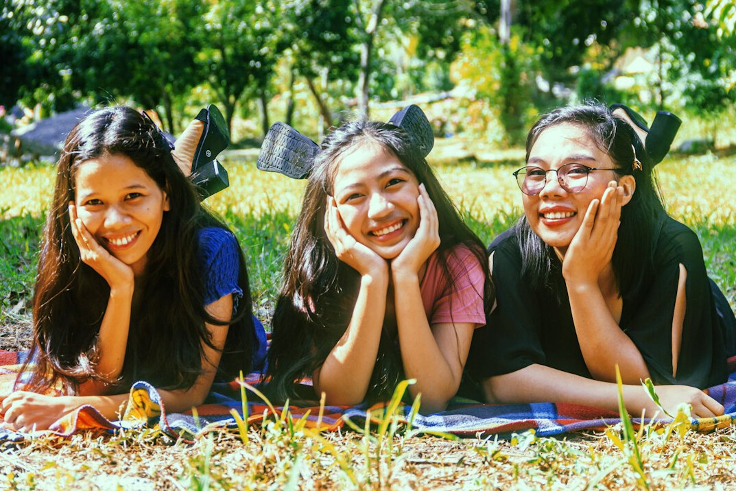 Group of Asian students studying together with laptops and notebooks