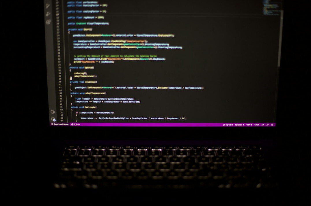 Young Malaysian student coding on a laptop at a desk