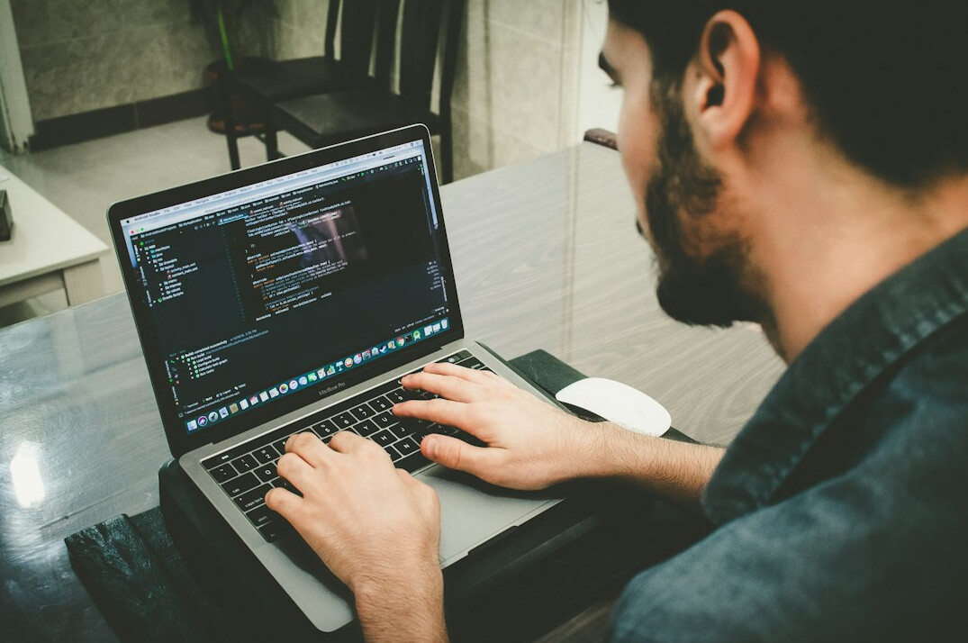 programmer coding on laptop